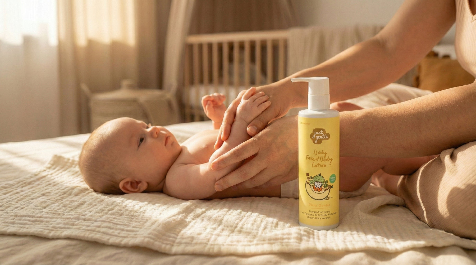 Baby lying on a bed with a bottle of Just Gentle baby lotion next to it, in a warm and cozy room.