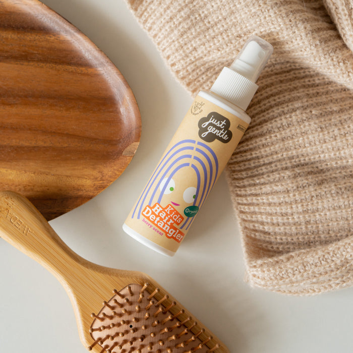 Just Gentle Kids Hair Detangler Spray with a wooden hairbrush and a towel