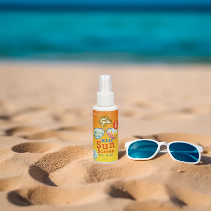 Just Gentle Kids Sunscreen Clear Spray SPF 50 PA+++ on sand beside swimming goggles