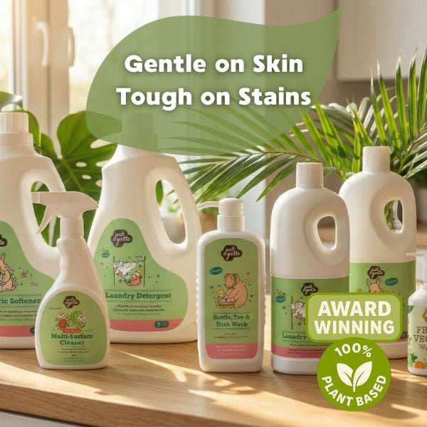 Collection of 'Just Gentle' eco-friendly cleaning products with visible branding on a wooden surface.