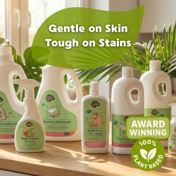 Collection of 'Just Gentle' eco-friendly cleaning products with visible branding on a wooden surface.