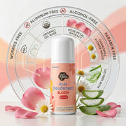 The Just Gentle 'Bloom' deodorant bottle centered in front of a circular, transparent ingredient graphic. It is surrounded by fresh rose petals, chamomile flowers, and aloe vera slices, visually representing its key organic ingredients and paraben-free formula.