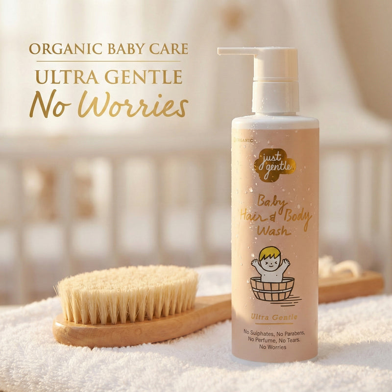 Just Gentle Baby hair and body wash bottle with a brush on a soft surface, featuring 'Just Gentle' branding.