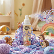 JUST GENTLE Hair detangler spray bottle with colorful yarn and toy animals in a playful setting