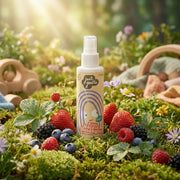 JUST GENTLE Hair detangler spray bottle surrounded by fruits and vegetables in a natural setting