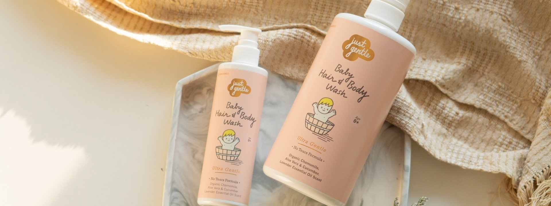Two bottles of 'Just Gentle' baby wash with a natural background