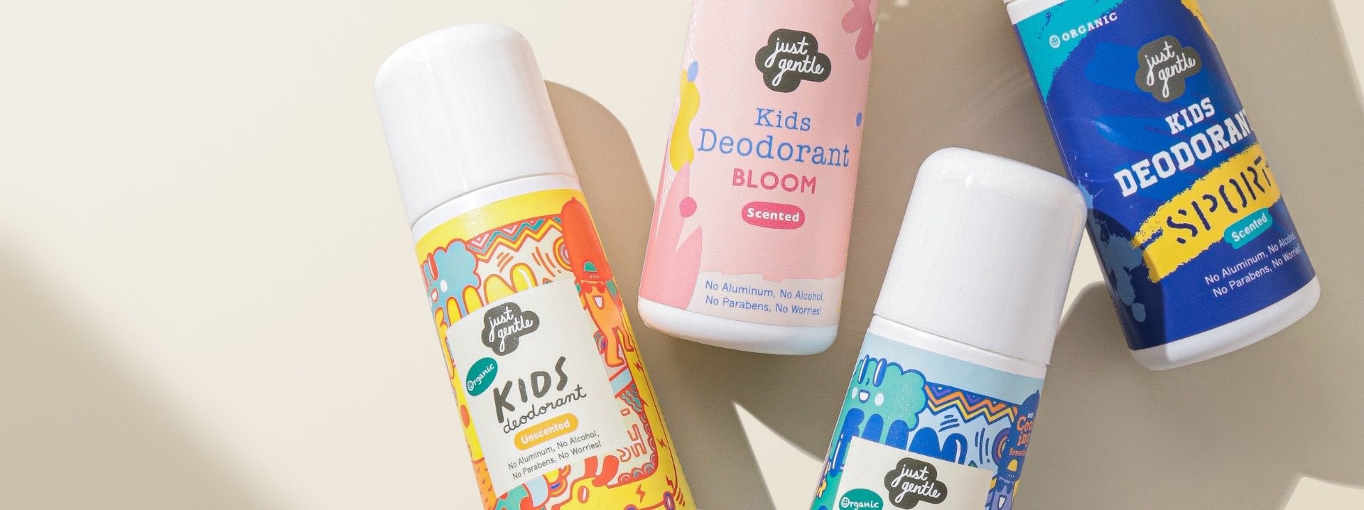 Four 'Just Gentle' children's deodorant bottles in various flavors on a light background