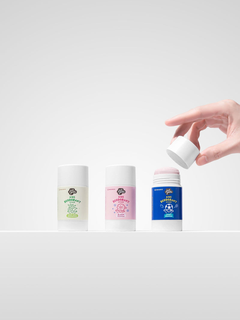 Hand opening Just Gentle kids sport deodorant next to unscented and bloom natural deodorant sticks